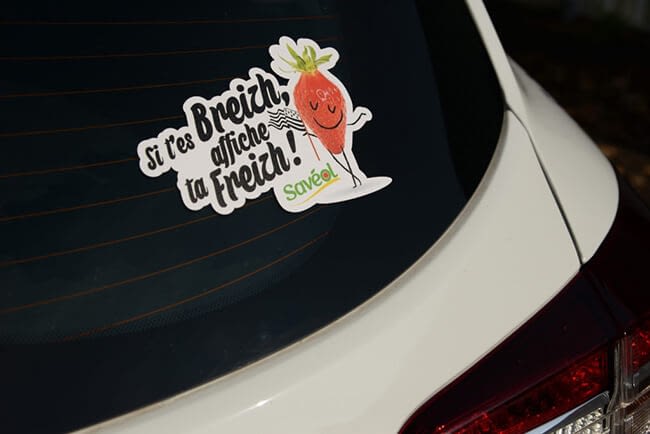 Etiquette adhésive avec texte et dessin de fraise sur le pare brise d'une voiture