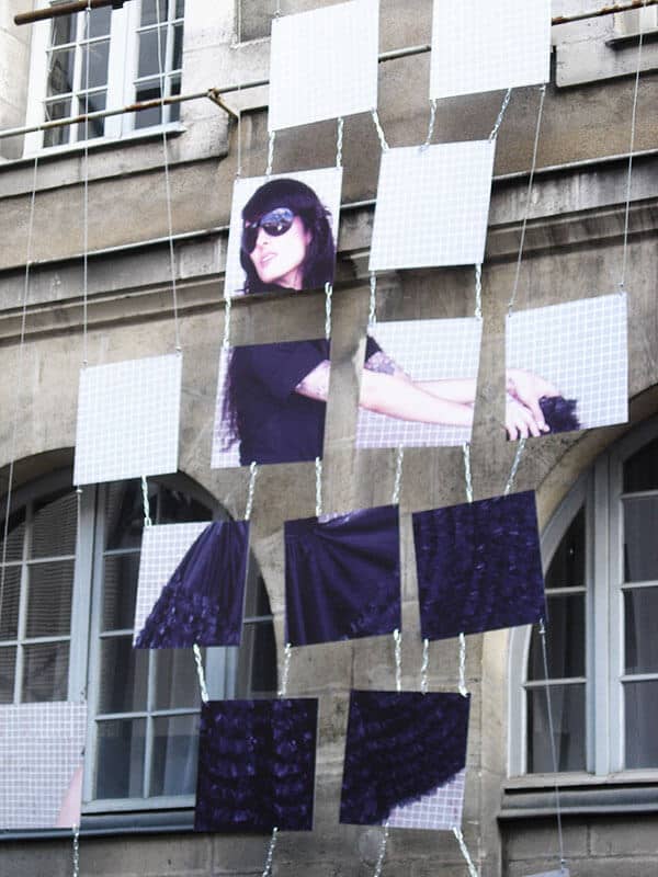 Visuel déstructuré avec photo de femme suspendu sur un mur en pierre